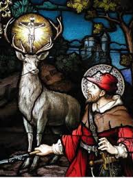 a stained glass window with a man holding a deer